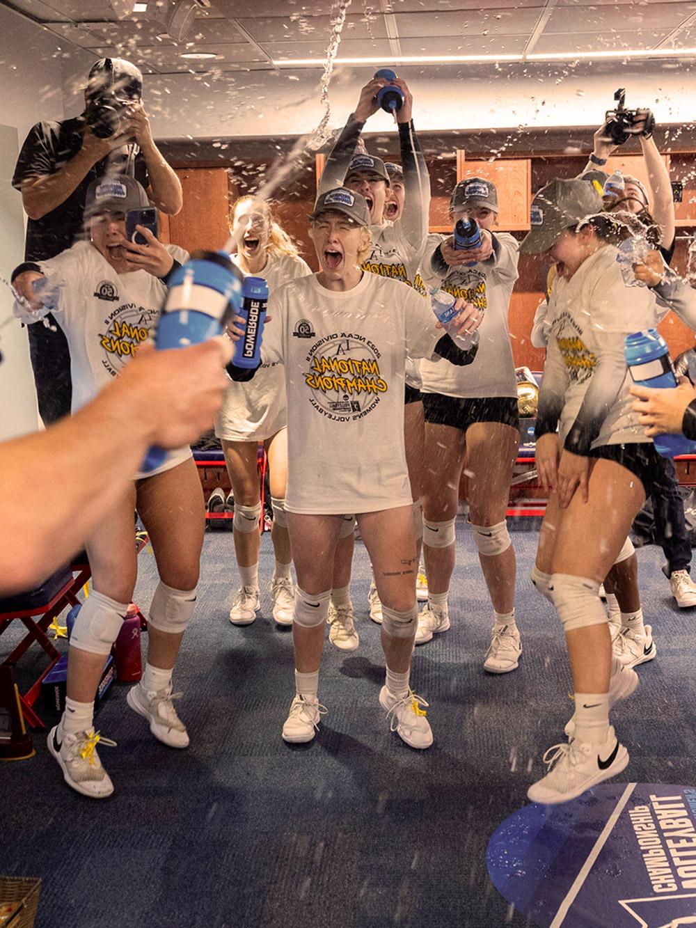 Womens volleyball team celebrating a win in the lockerroom.